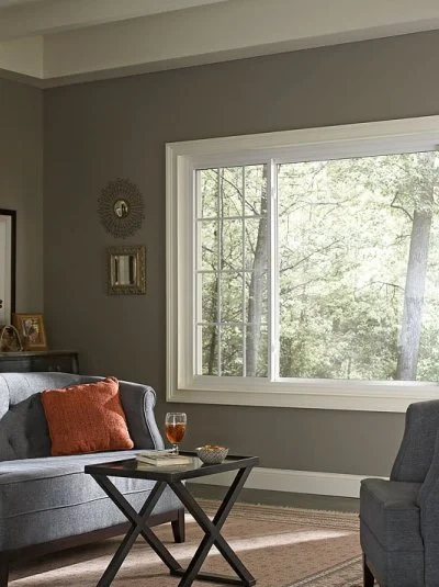 Sitting room with a wide window, a gray sofa and a side table
