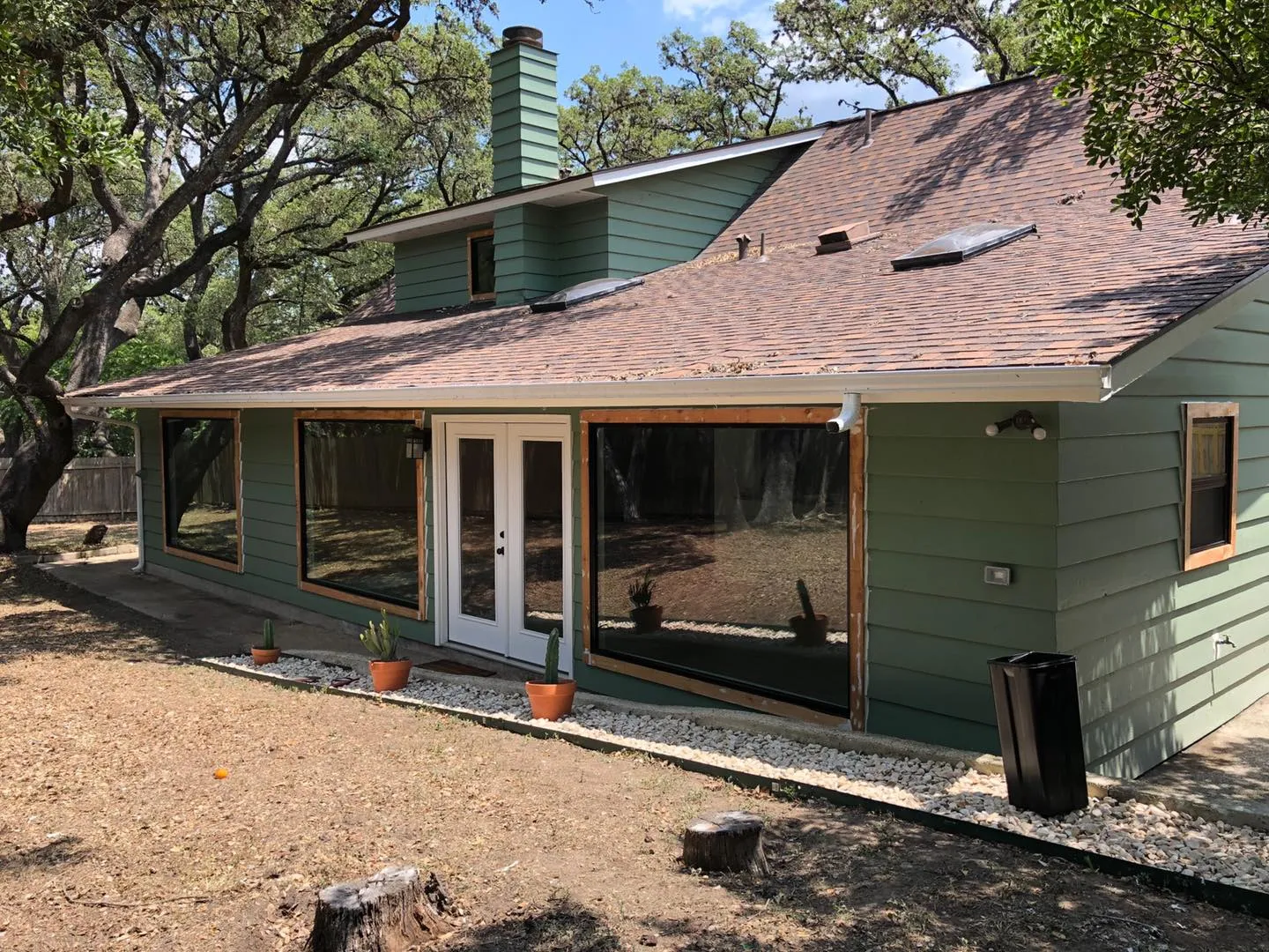 Back of a one-story house with new windows and a French door