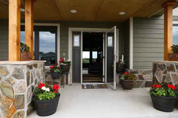 Glass storm door on a covered front porch with potted flowers