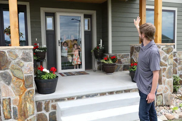 Man pointing to a glass storm door on a stone front porch