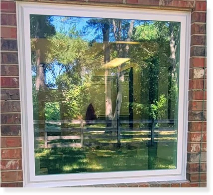 Large picture window in a brick wall looking out on trees