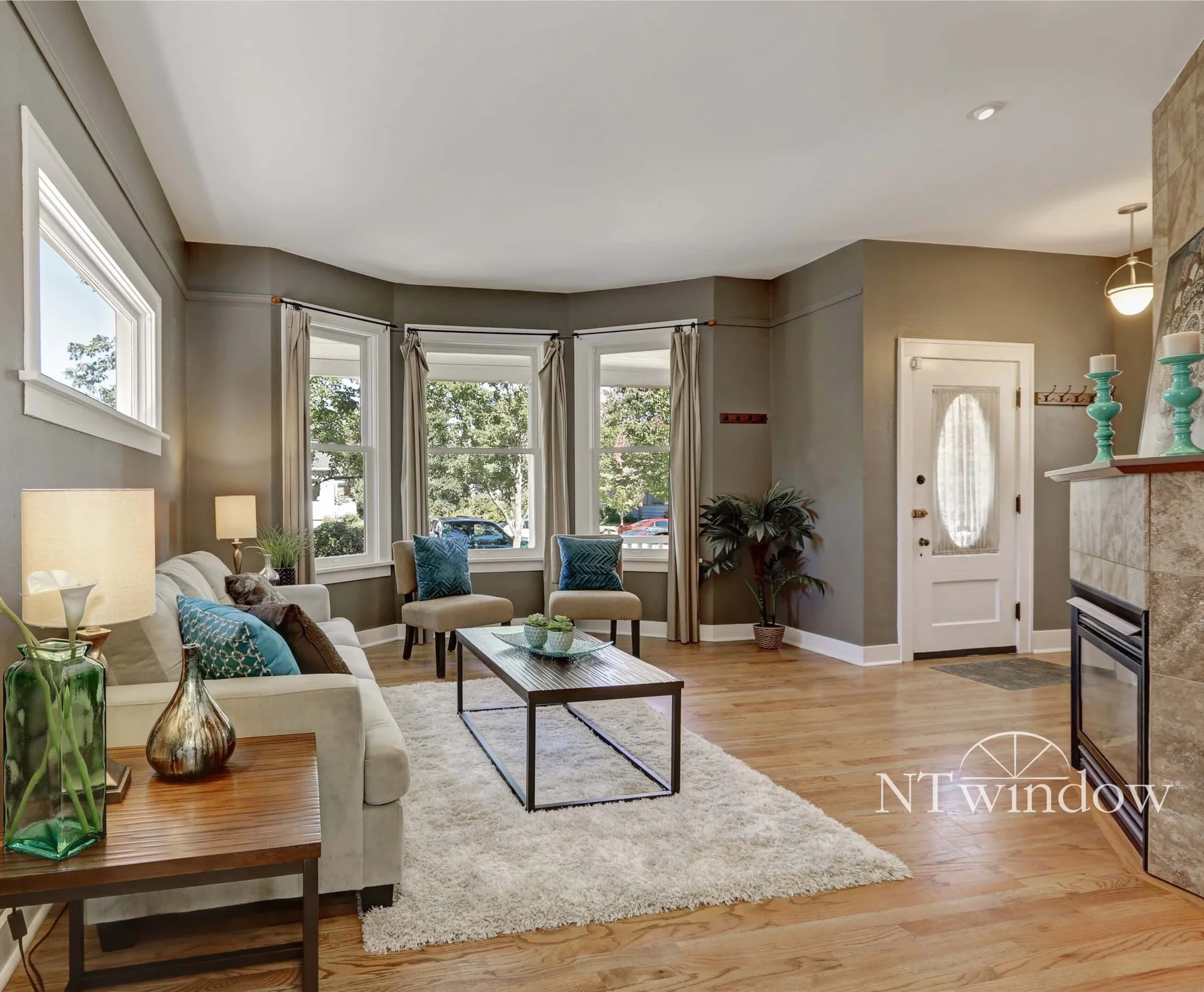 Living room with a bay of tall windows and a front door