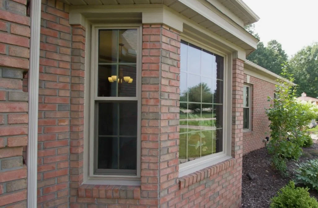 Brick home with new windows in a bay and along the side wall