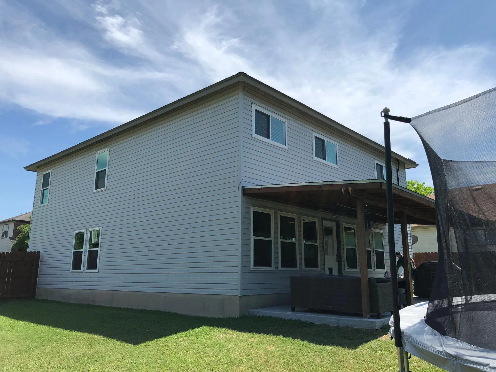 Back of a two-story house with vinyl siding and new windows