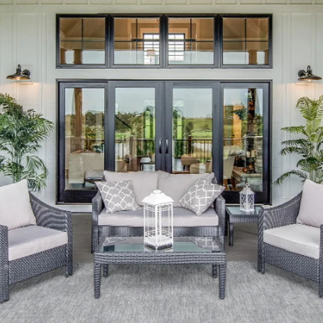 Covered patio with outdoor seating in front of glass doors and windows