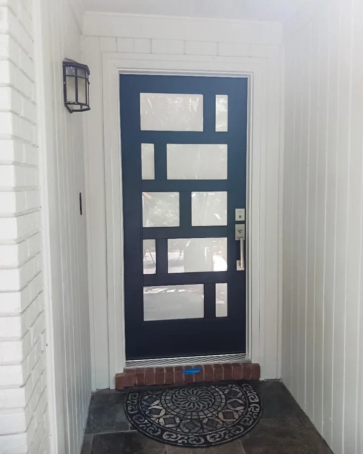 Modern navy front door with rows of small glass lites