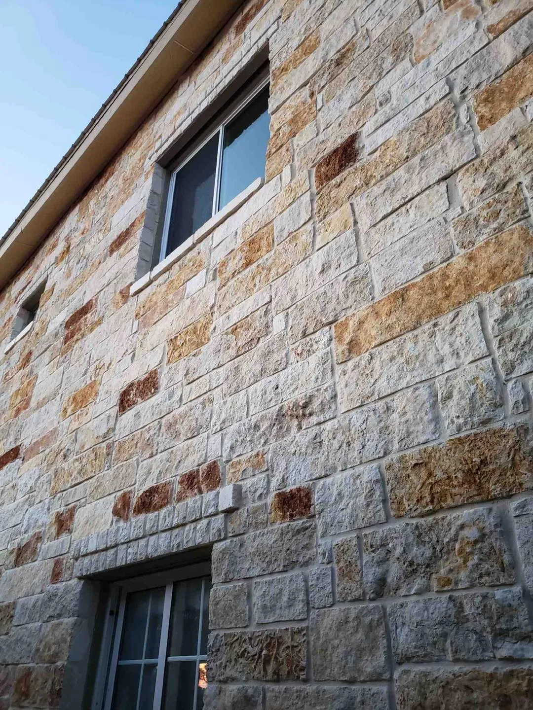 Stone wall with new windows on two floors