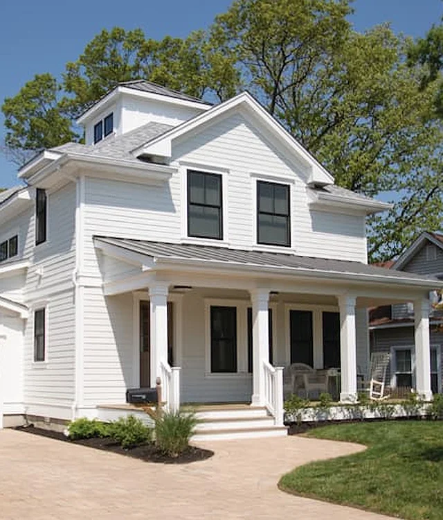 White two-story home with black windows and a front porch
