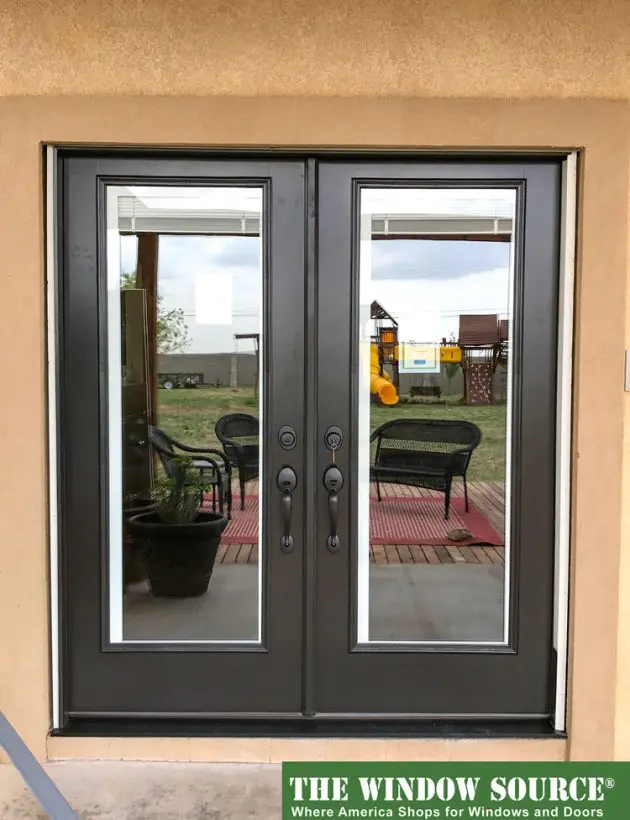 Double glass storm doors with black frames and decorative handles by The Window Source, showcasing energy-efficient installation for Houston homes with patio access.